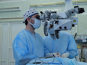 Picture of surgeon using a microscope in operation to remove brain tumors,