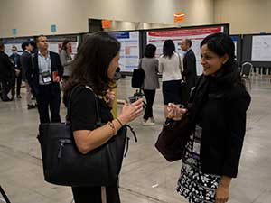 Two people at a poster session at SABCS 2022.