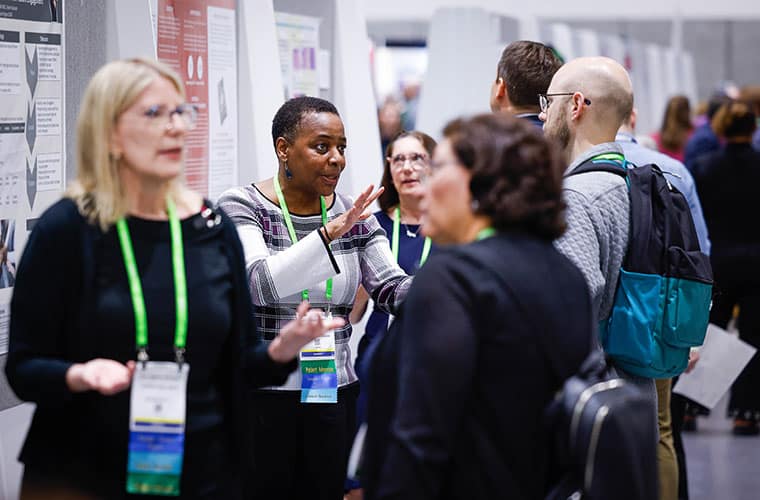 Clare Cruickshank speaking to an attendee at the Patient Advocacy Poster Session during the AACR Annual Meeting 2024.